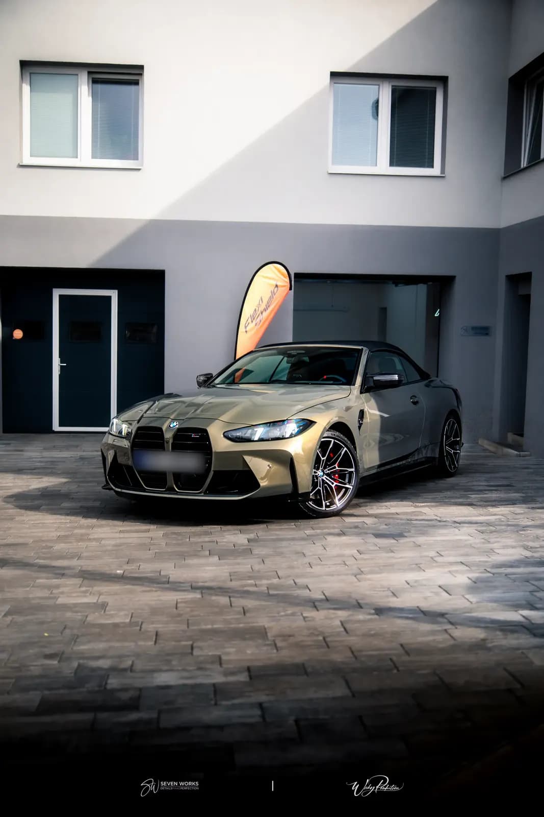 Zlatavé BMW M4 Cabrio zaparkované před provozovnou, přední boční pohled.