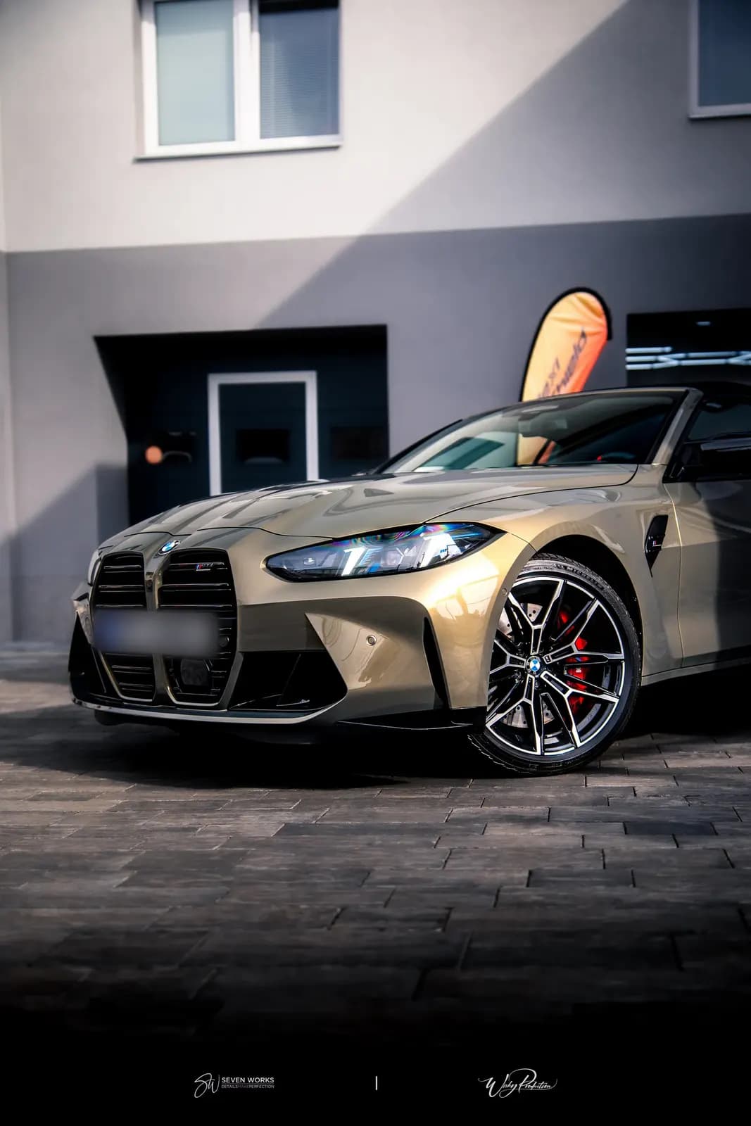Zlatavé BMW M4 zepředu zboku před provozovnou.