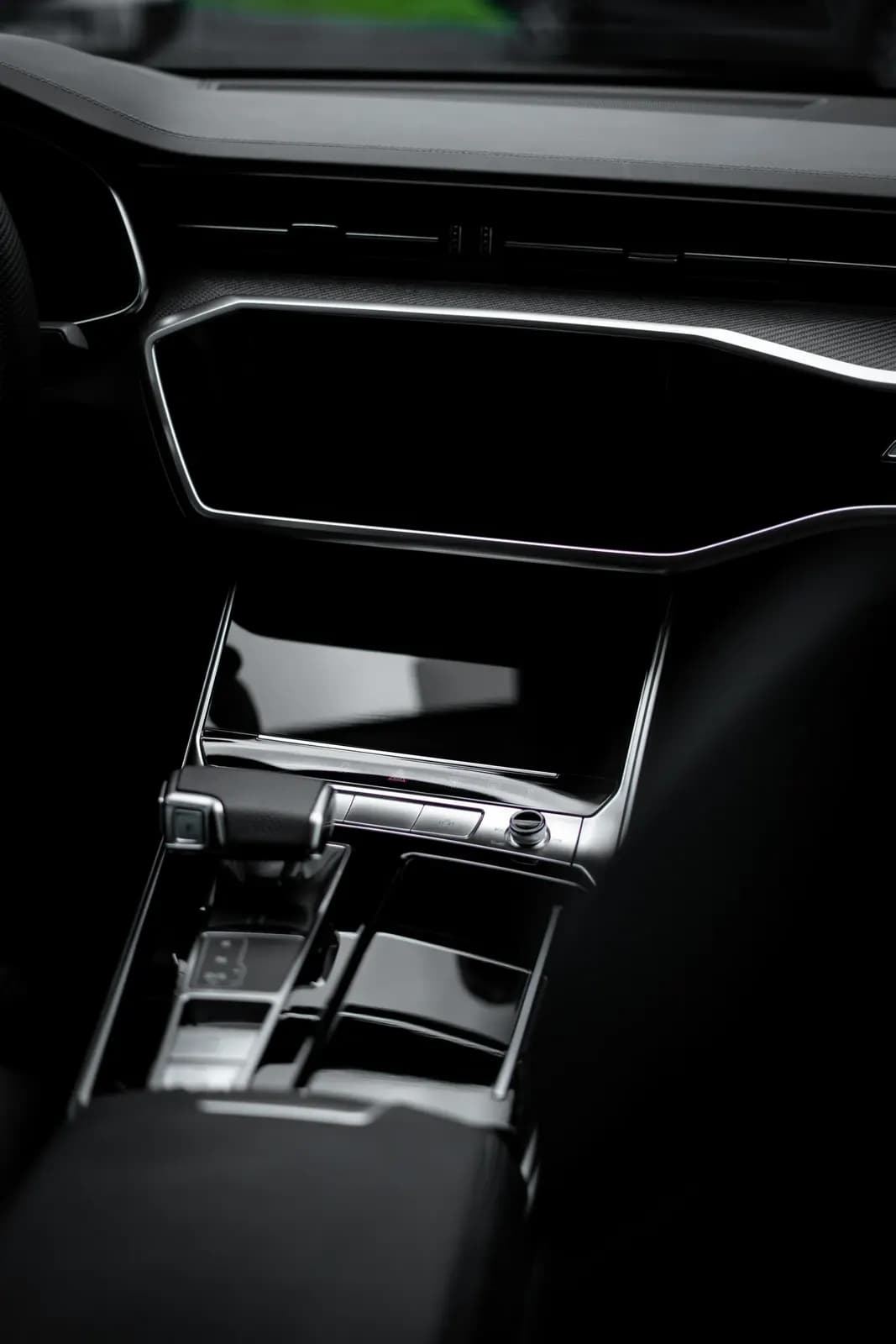 Detail centrálního displeje a středového panelu vozu Audi.