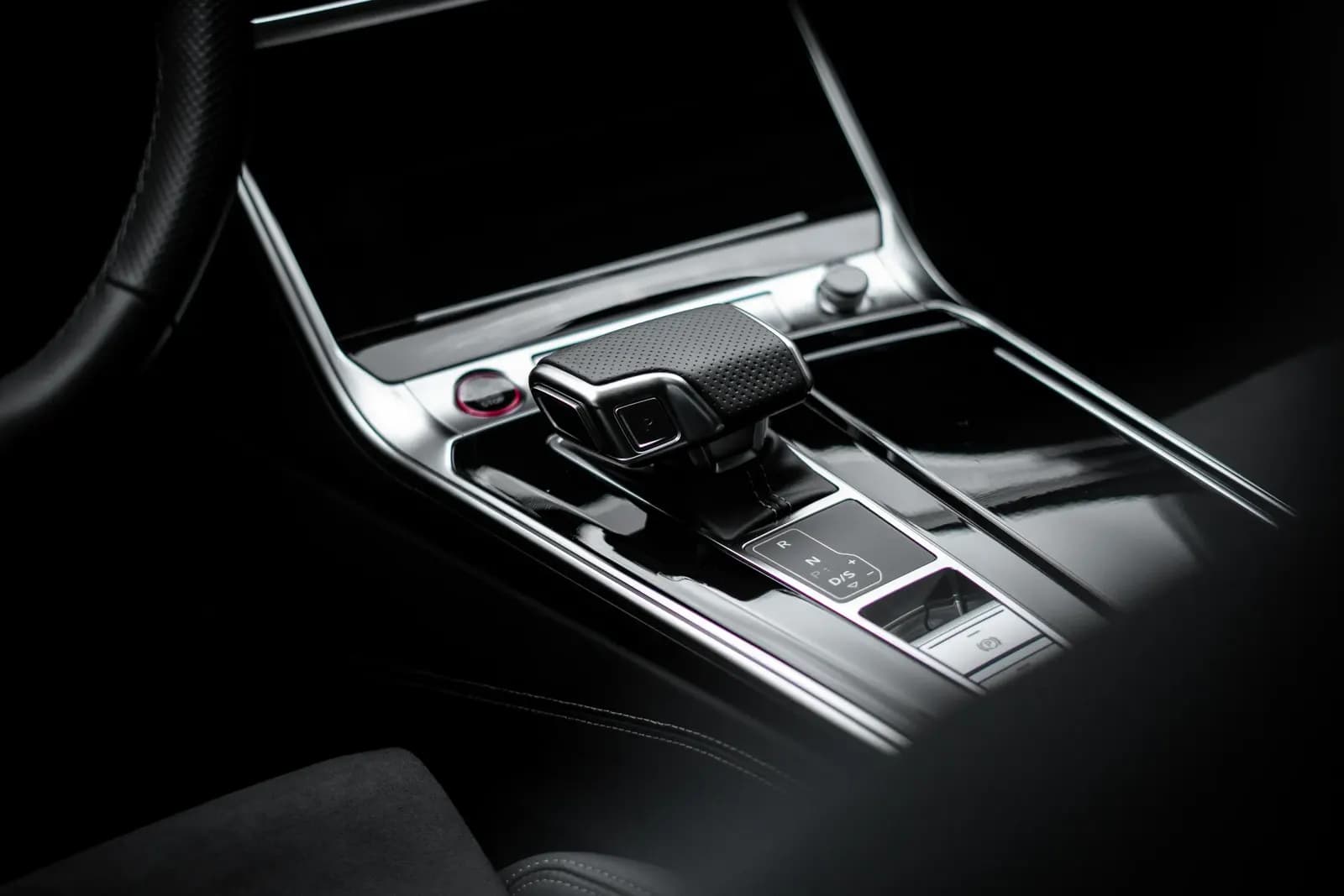 Close-up of the gear selector and glossy centre console in an Audi interior.