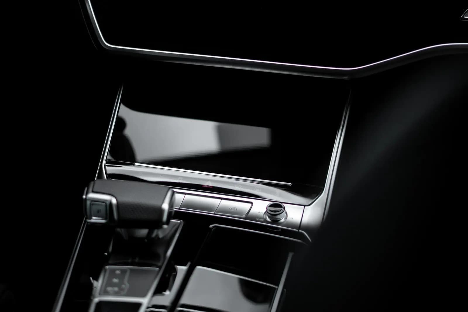 Close-up of a blank infotainment touchscreen in the car's centre console.