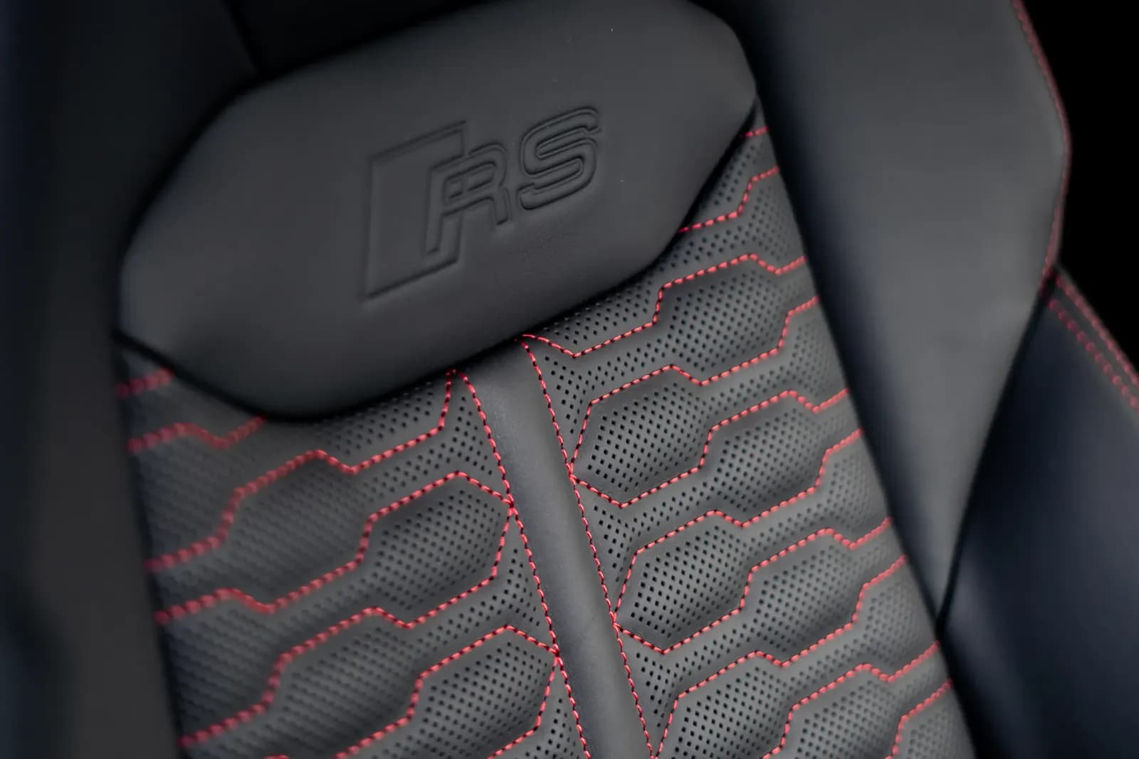 Close-up of a stitched RS sport headrest with red contrast stitching.