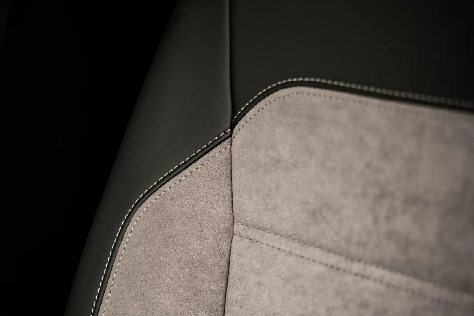 Close-up of a seat backrest's stitching, combining leather and alcantara.