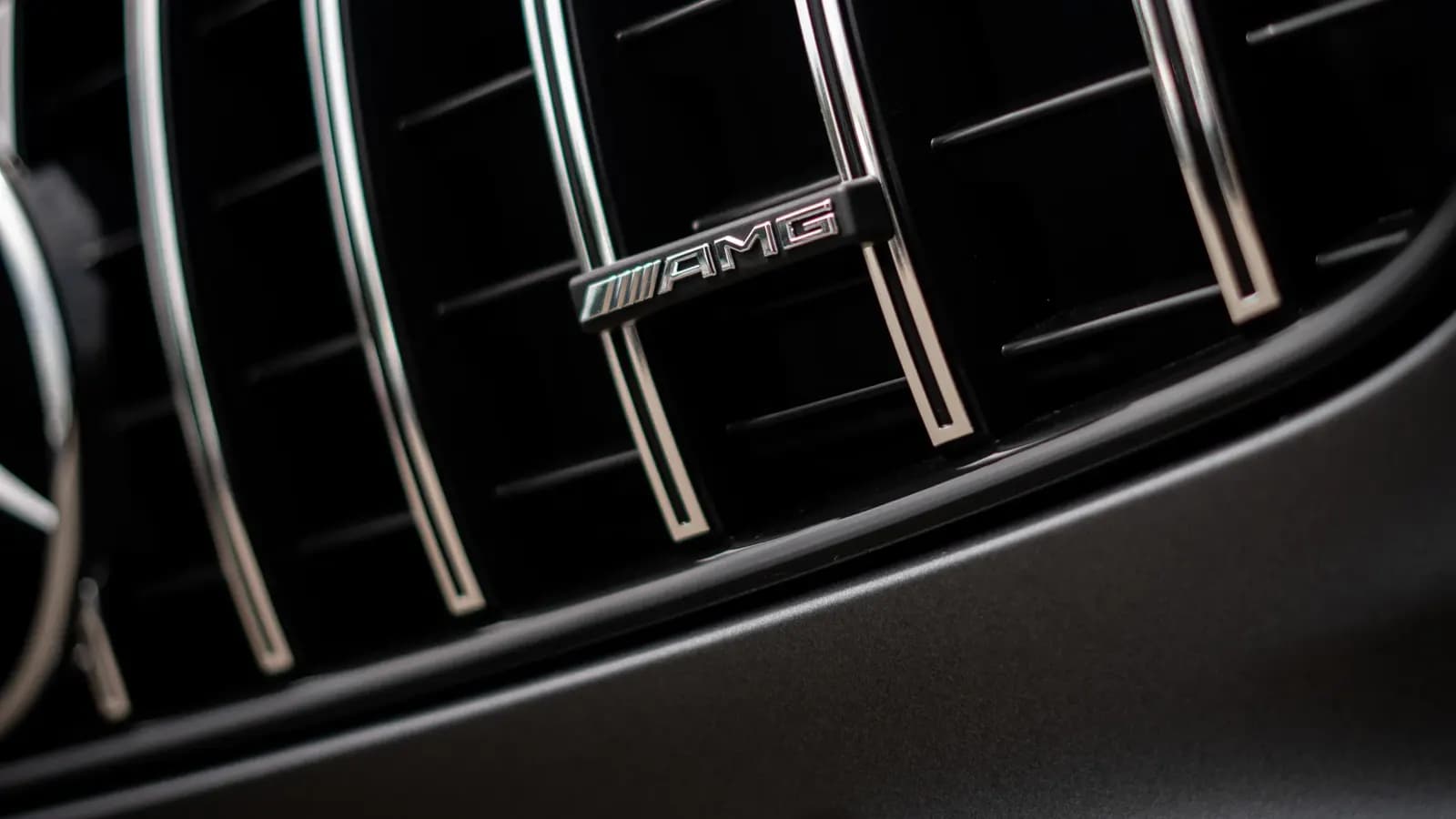 Close-up of the grille with an AMG badge on a dark grey Mercedes-Benz.
