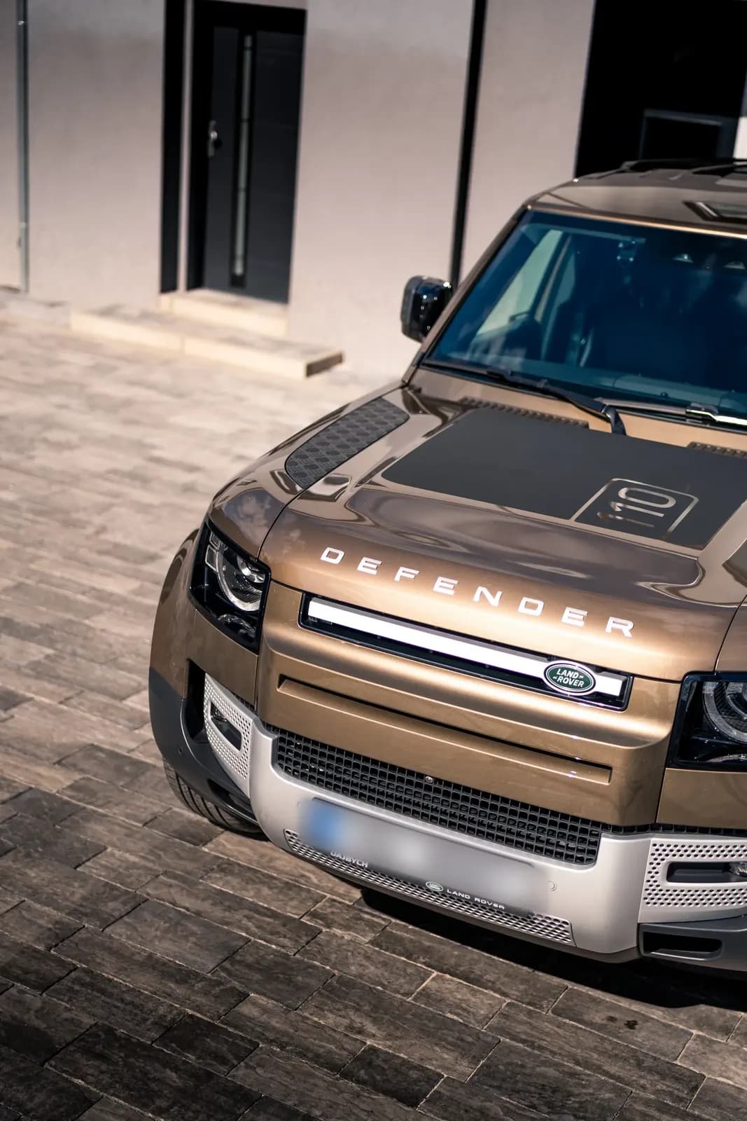 Close-up of the front grille and bonnet of a Land Rover Defender with the Defender lettering.