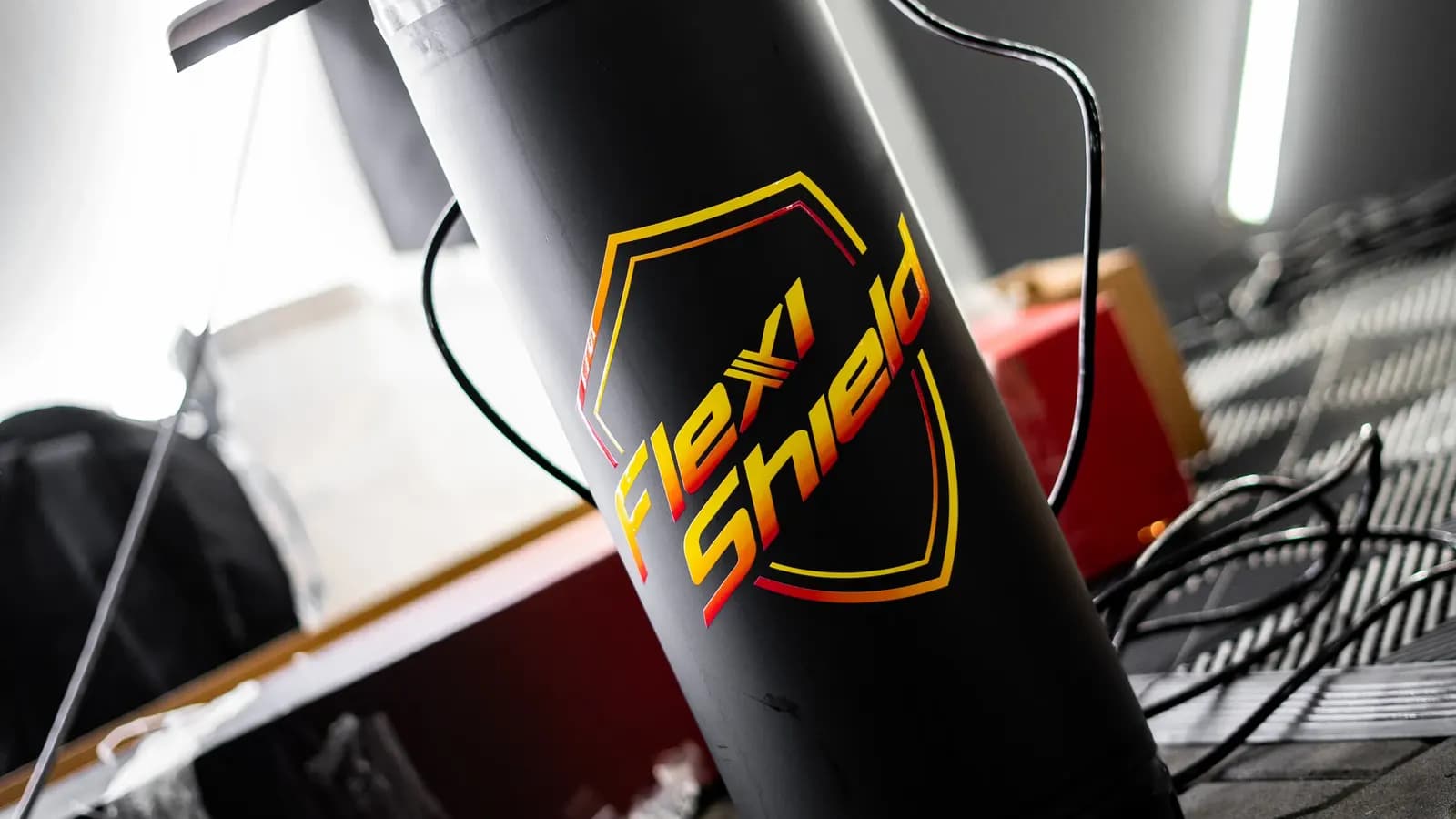 Černý válec s logem Flexi Shield používaný při instalaci ochranné fólie.
