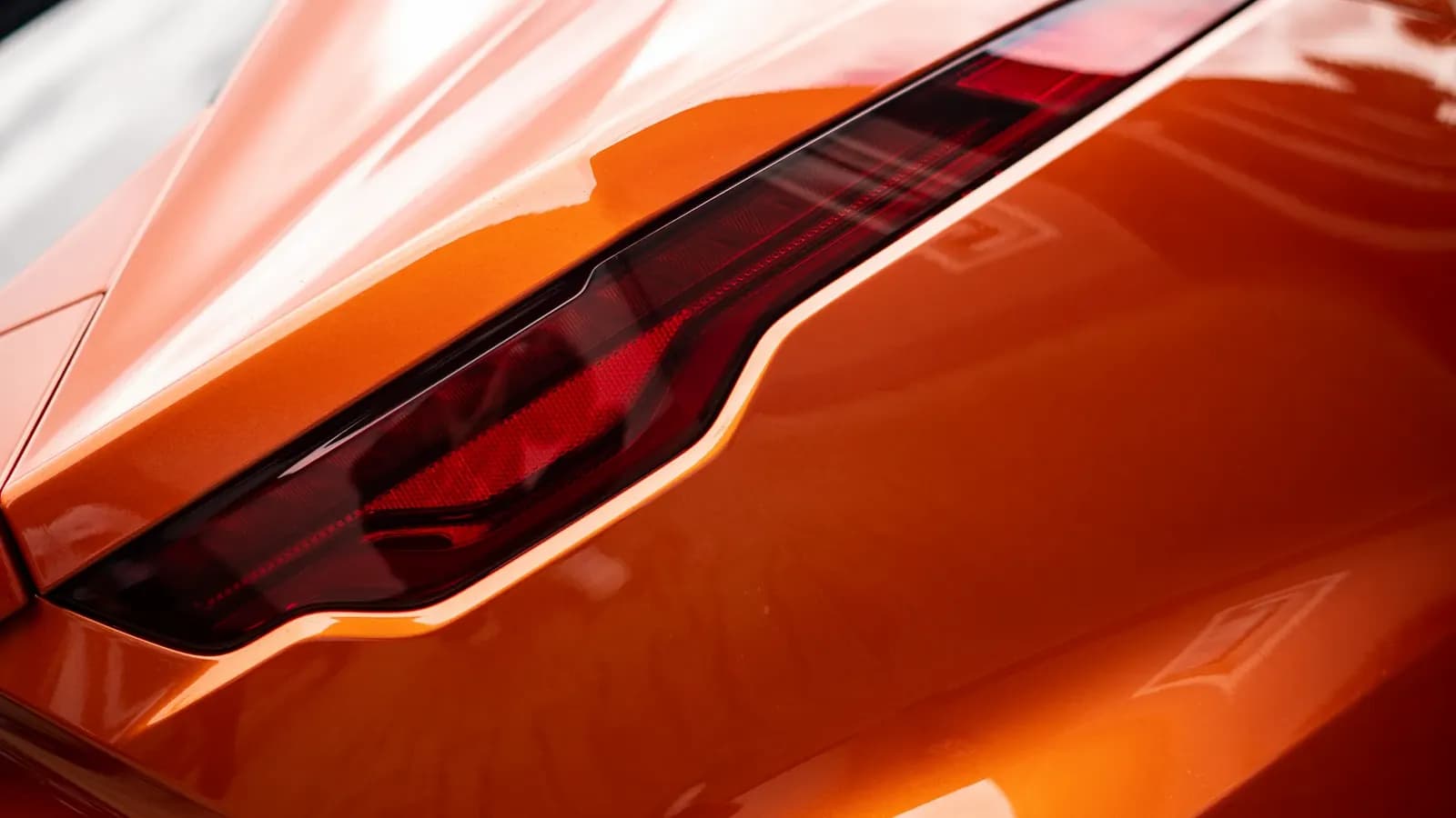 Side close-up of the tail light on an orange car.
