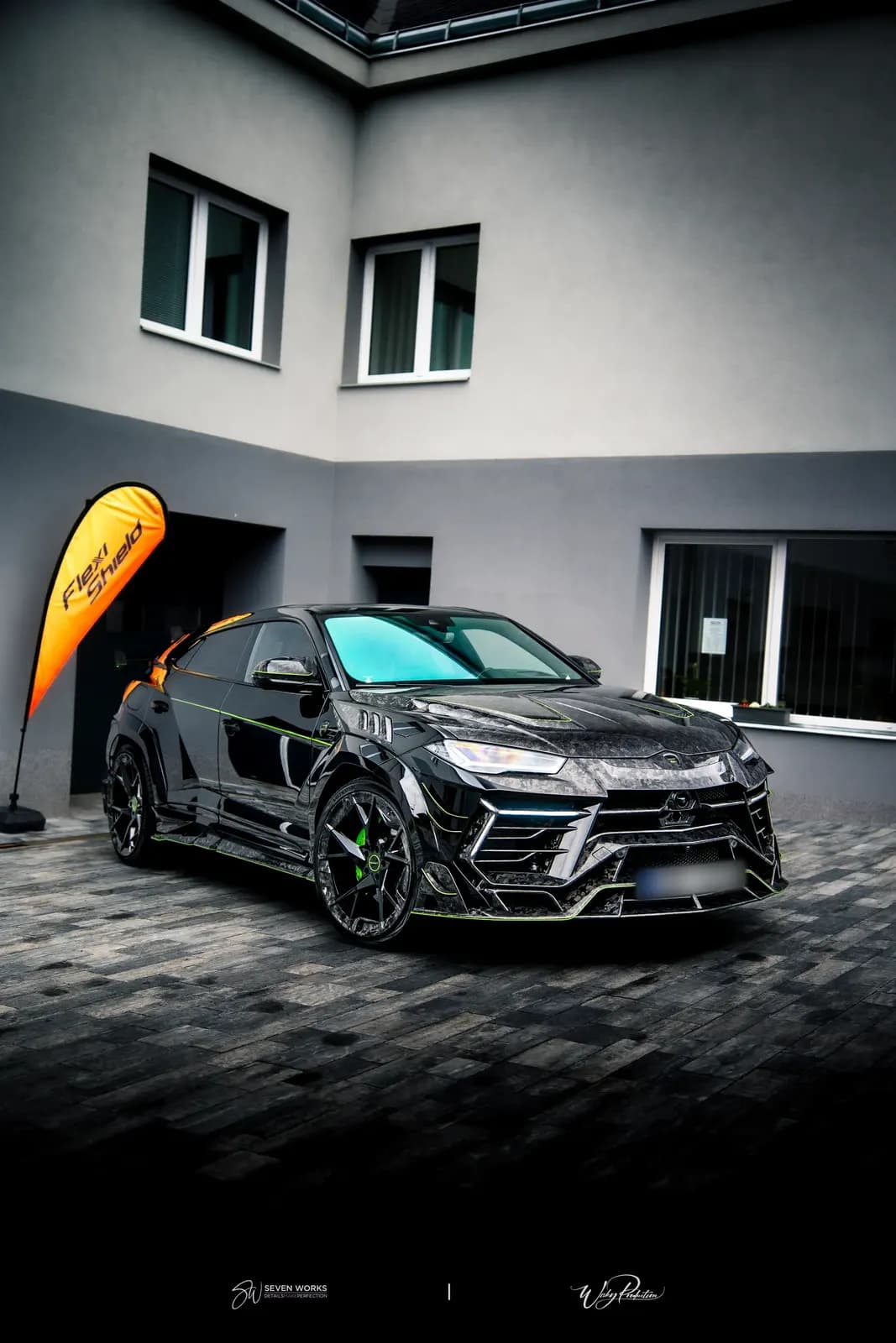 Black sports SUV with a bold design wrap in a carbon-camo pattern with green accents.