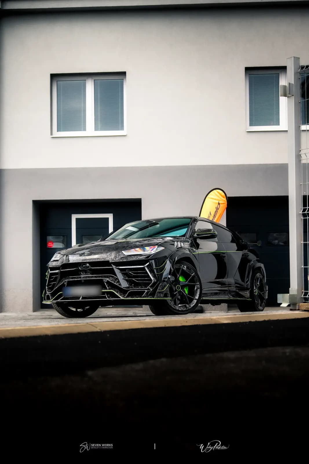 Lamborghini Urus zaparkovaný před domem v podvečerním nasvícení, pohled zepředu-boku.