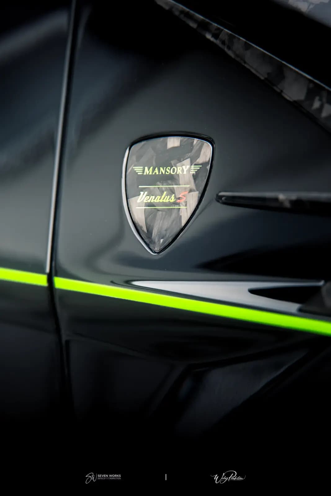 Detail odznaku Mansory na karoserii vozu se zeleným pruhem.