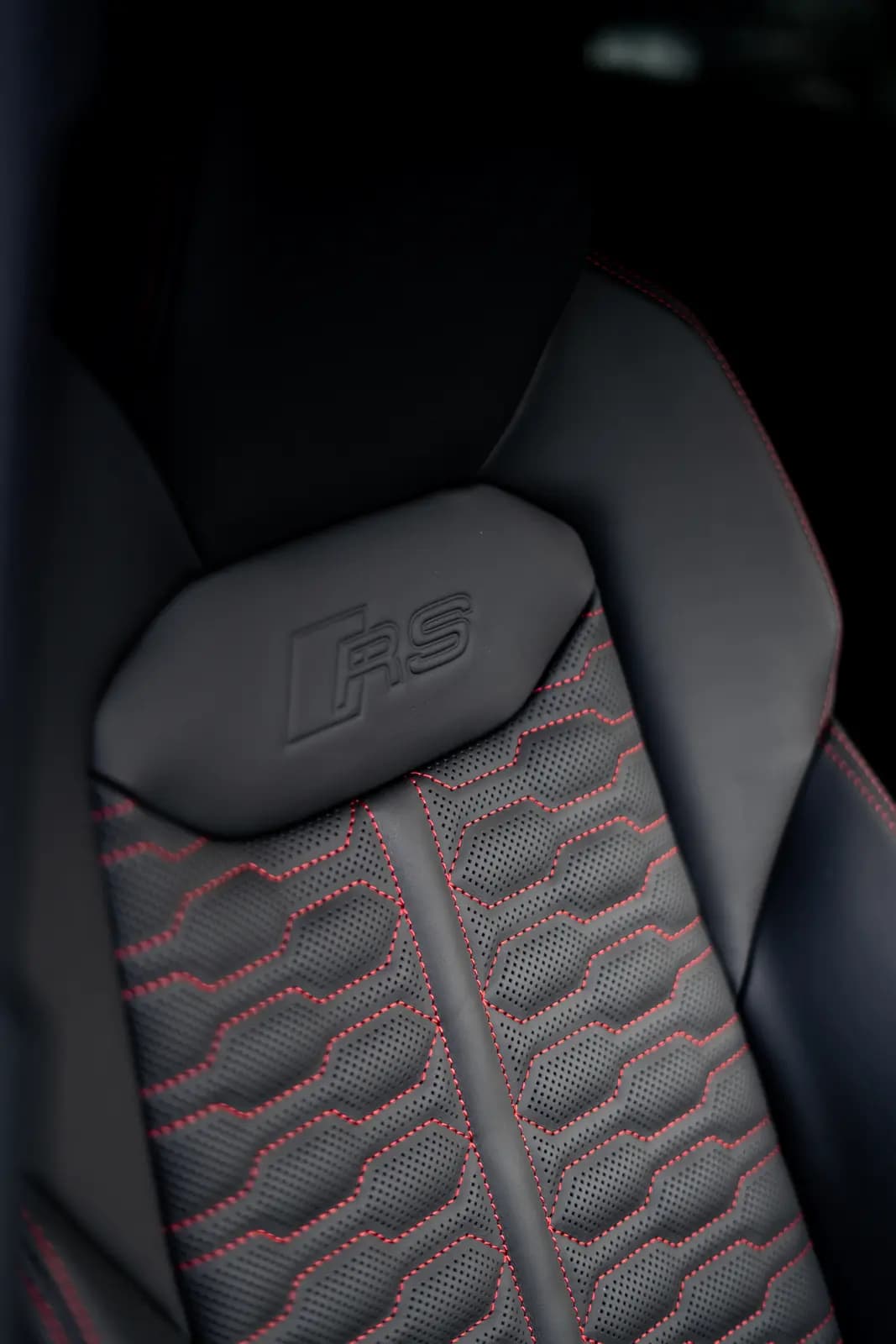 Headrest with an embossed “RS” logo, black leather with red stitching.