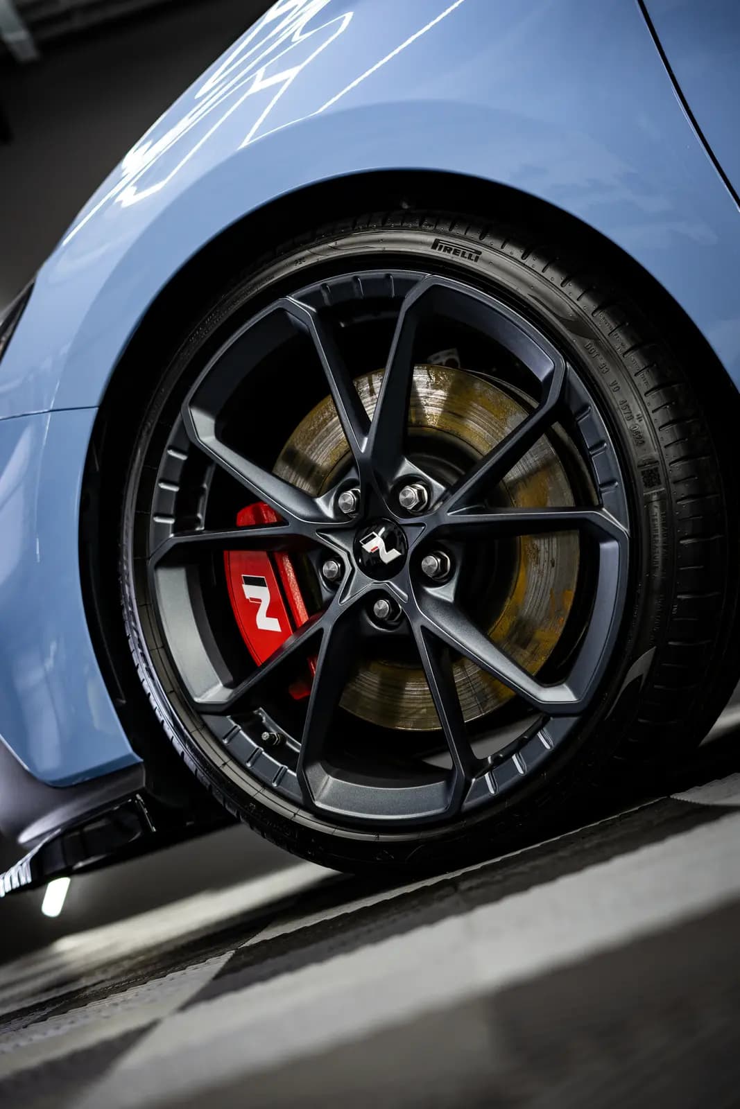 Wheel with a red brake caliper carrying an N logo and a Pirelli tyre.