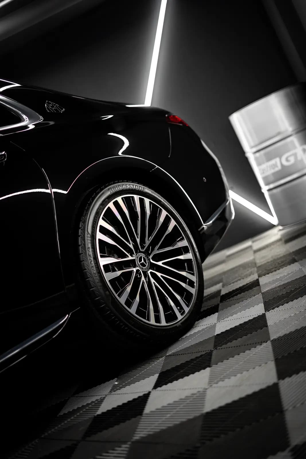 Rear wheel of a black Mercedes-Maybach, BRIDGESTONE legible on the tyre and the Mercedes badge on the centre cap, a drum marked GTX behind.