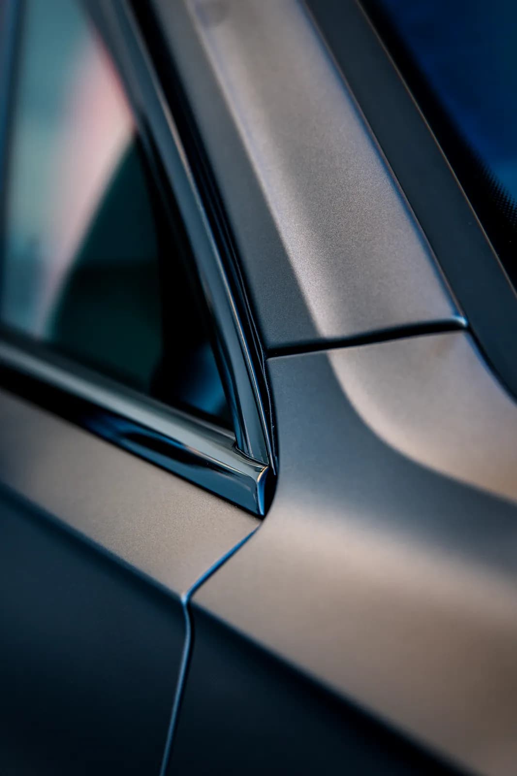 Detail sloupku a okenního rámu Volkswagenu Touareg, matný povrch fólie na sloupku.
