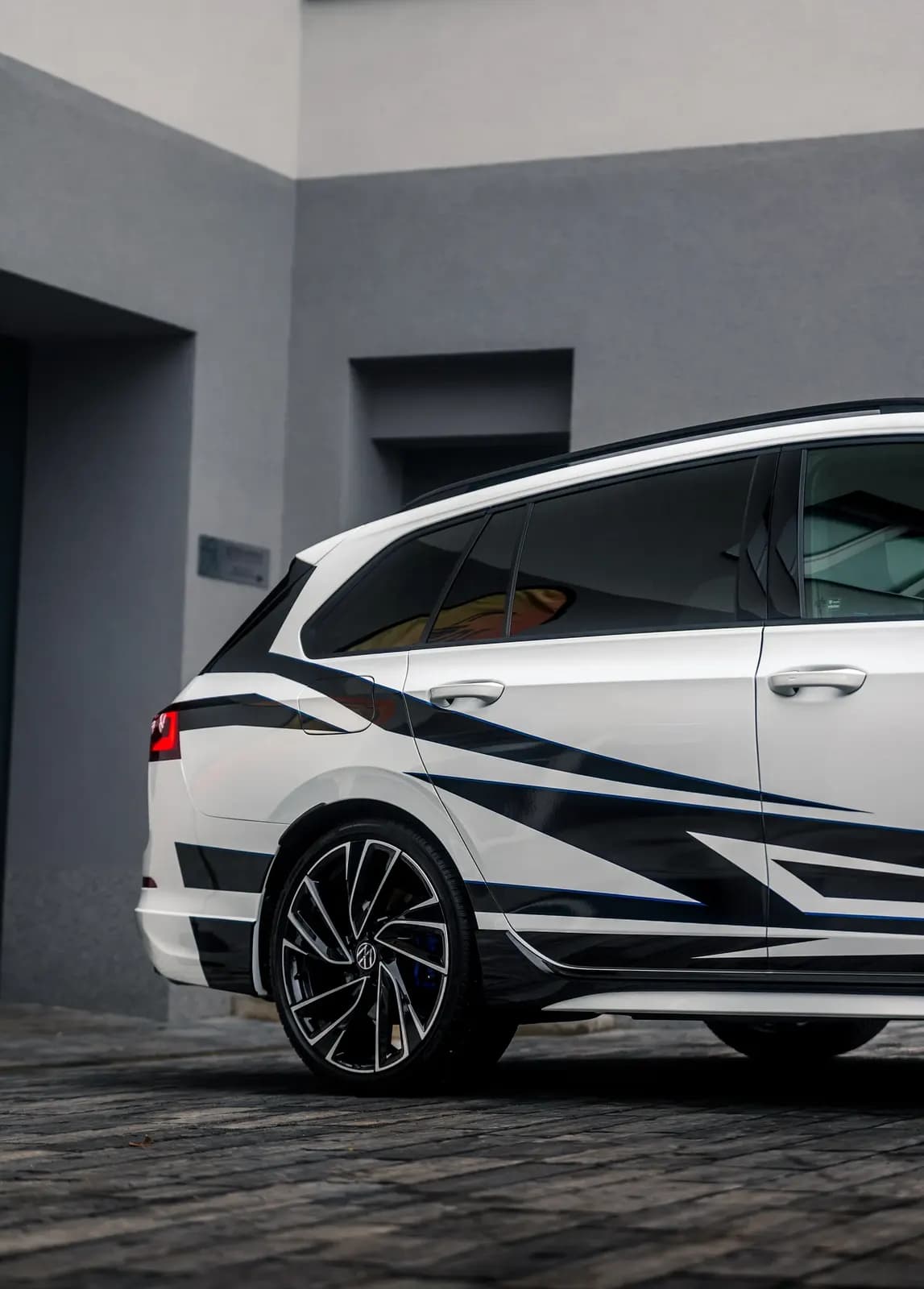 Zadní tříčtvrteční záběr vozu s ostrým geometrickým designovým polepem.