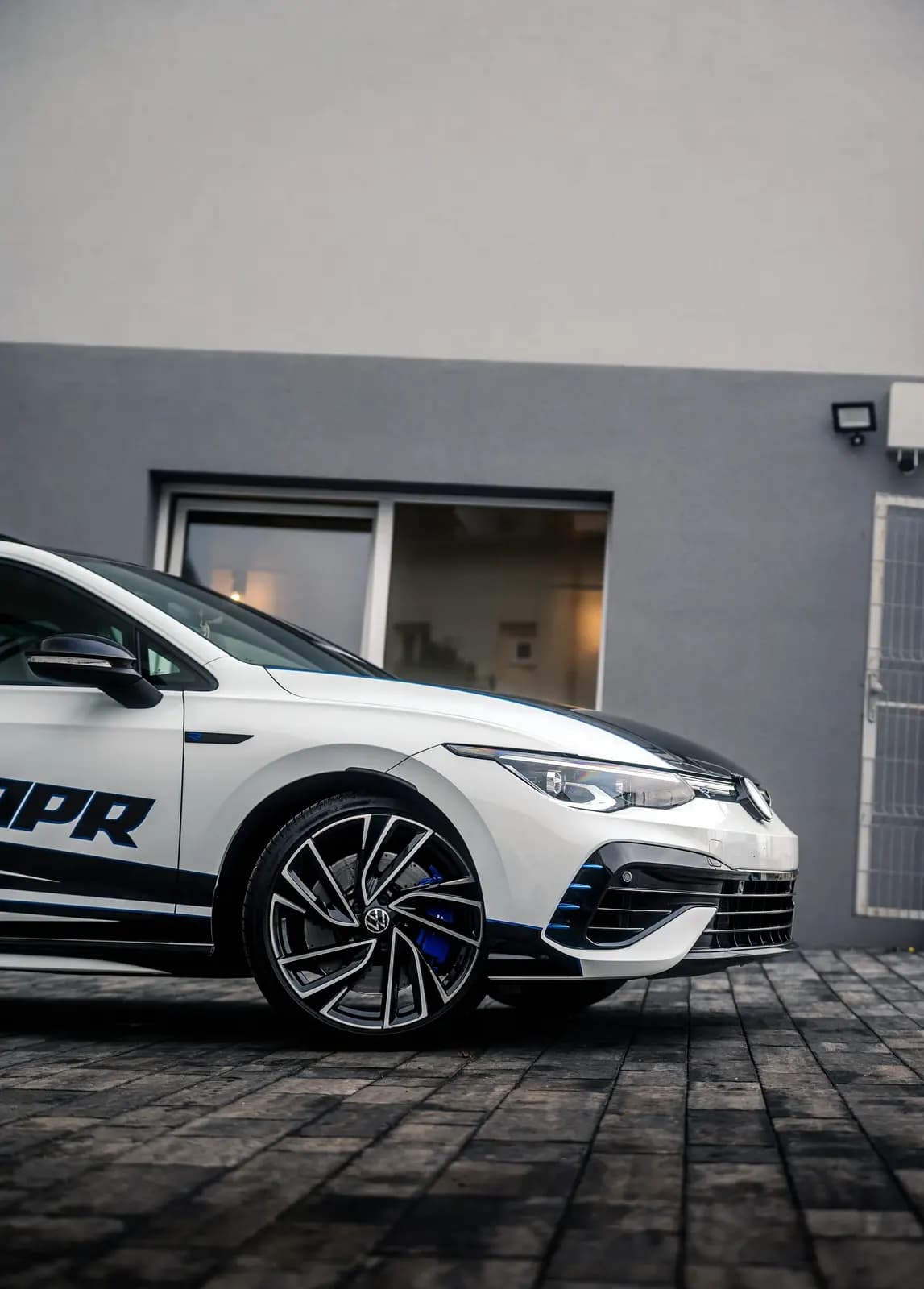 Boční profil vozu VW s nápisem APR a modročerným designovým polepem.