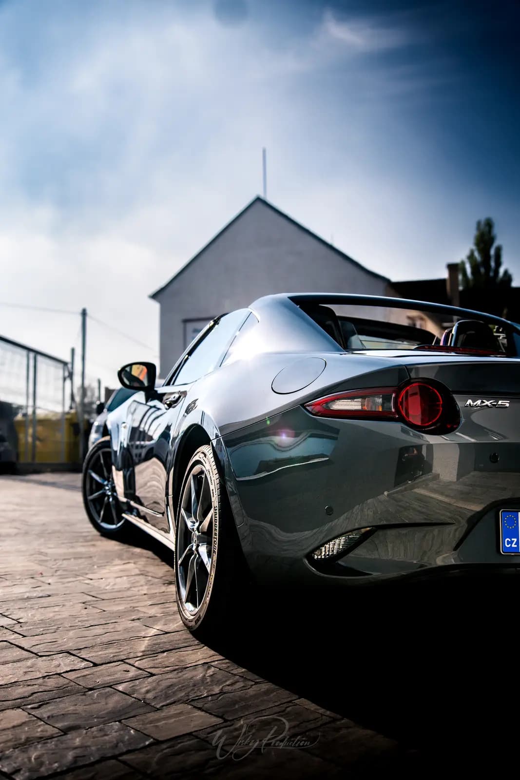 The rear of a Mazda MX-5 with its round tail light and the MX-5 badge on the lid.