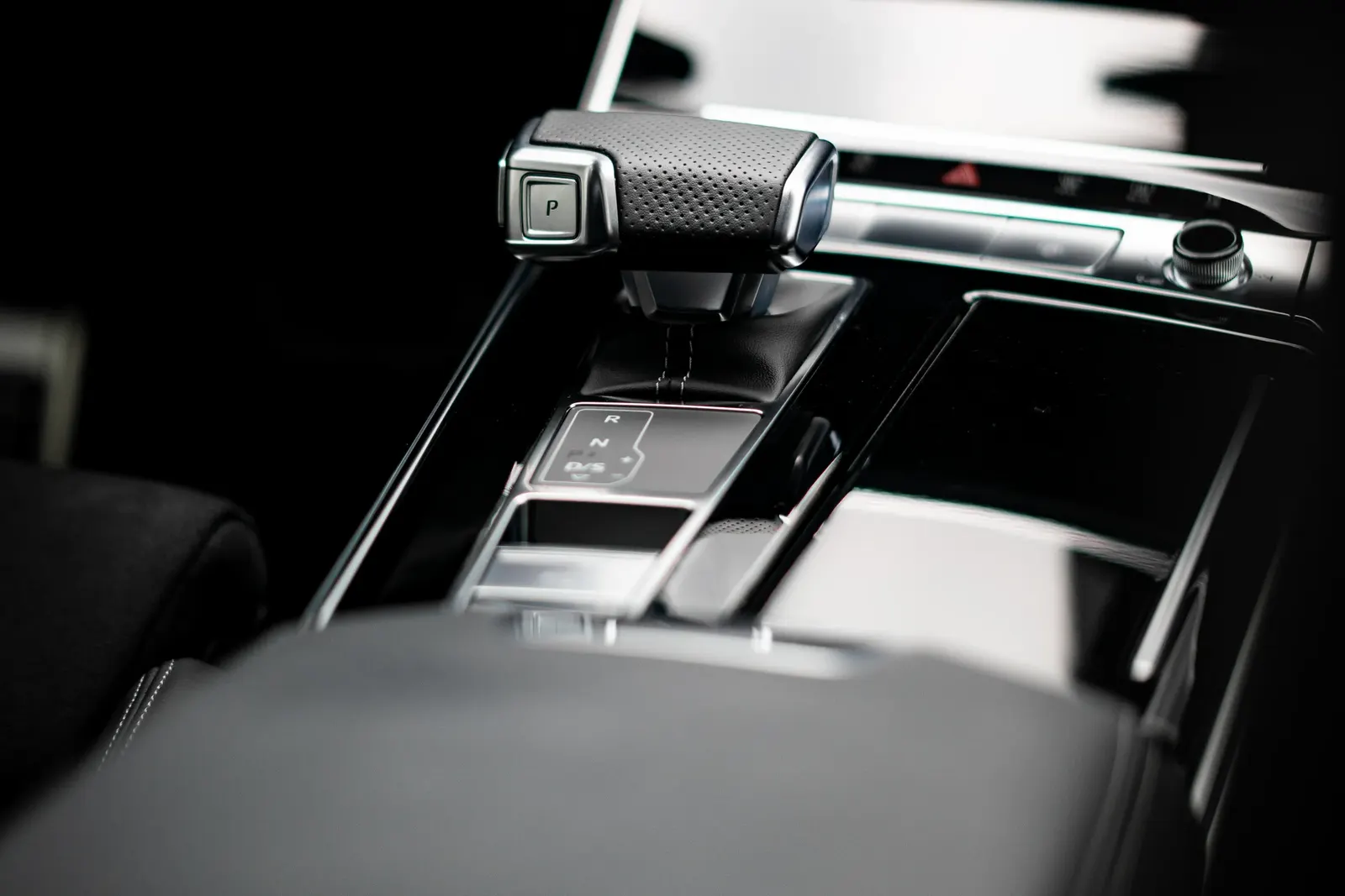 Detail automatické řadicí páky s tlačítkem P v luxusním interiéru vozu.