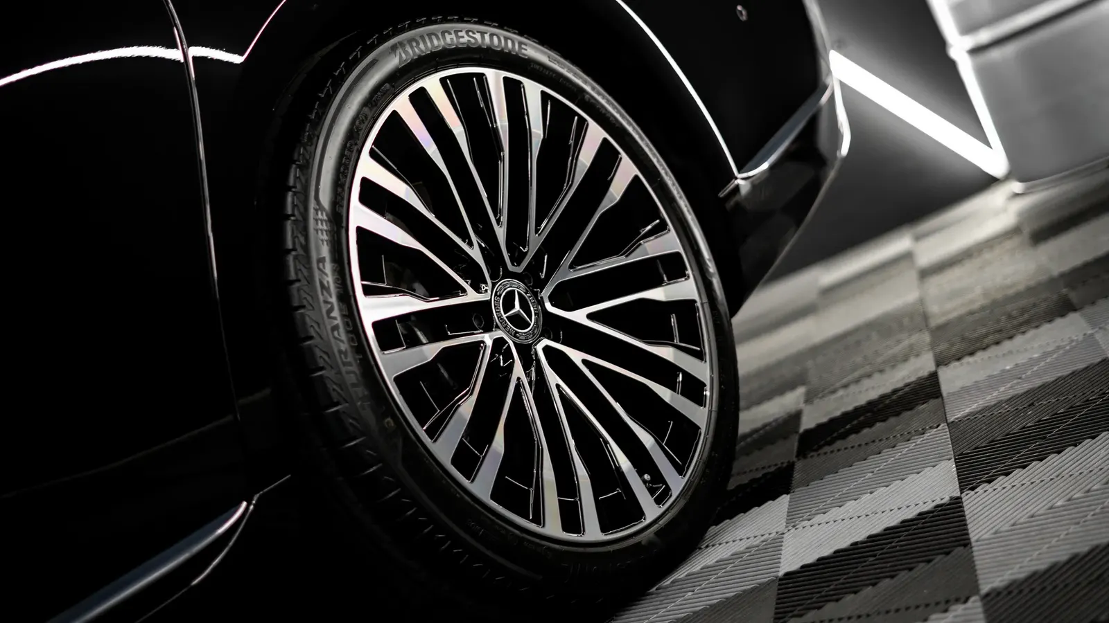 Detail lesklého kola s logem Mercedes-Benz na černém voze.