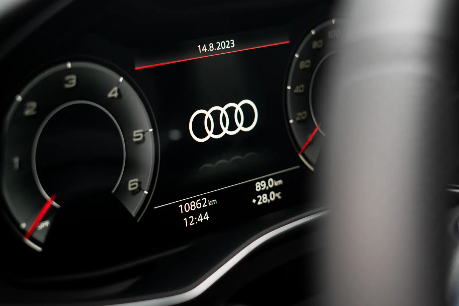 Detail digitálního přístrojového štítu s logem Audi, datem 14.8.2023 a stavem tachometru 10862 km.