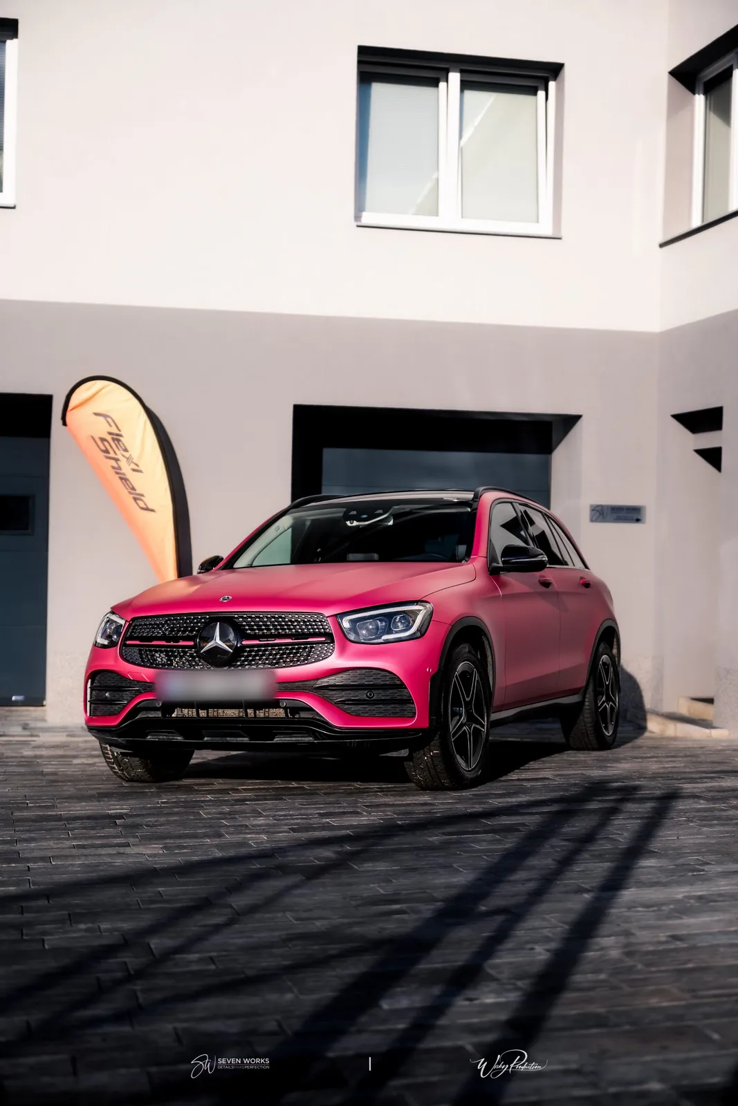Pink-wrapped Mercedes-Benz SUV from the front outside the workshop.